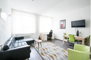 Central Apartments Aalen في آلين: غرفة معيشة مع أريكة وطاولة