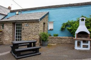 un edificio blu con una panchina e una casetta per uccelli di Yetland Farm Holiday Cottages a Combe Martin