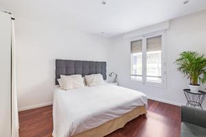 um quarto branco com uma cama grande e uma janela em Appartement Charles - Welkeys em Marselha