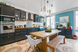 uma cozinha com armários azuis e uma mesa de madeira em Appartement Charles - Welkeys em Marselha