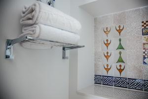 a pile of towels on a towel rack in a bathroom at HOTEL TRIANA MONTALVAN in Seville