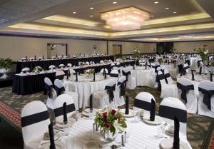 um grande salão de banquetes com mesas e cadeiras brancas em Crowne Plaza Indianapolis-Airport, an IHG Hotel em Indianápolis