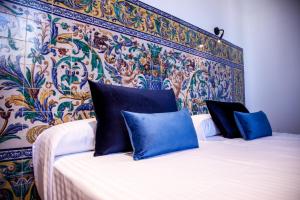 a bedroom with two blue pillows on a bed at HOTEL TRIANA MONTALVAN in Seville +37 photos