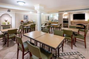 a restaurant with tables and chairs and a kitchen at La Quinta East Deerfield Beach - Boca Raton in Deerfield Beach