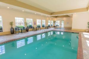 a swimming pool in a hotel with tables and chairs at La Quinta by Wyndham Bentonville in Bentonville