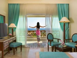een vrouw in een hotelkamer die uit het raam kijkt bij Movenpick Taba Resort & Spa in Taba