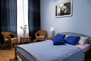 um quarto com uma cama com lençóis e cadeiras azuis em Hotel-Pension Charlottenburg em Berlim