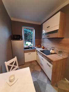 eine Küche mit einer Spüle, einem Kühlschrank und einem Tisch in der Unterkunft Warszawska in Legionowo