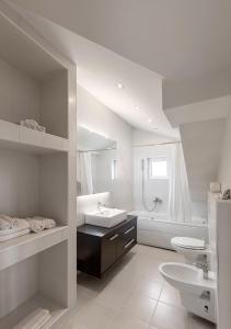 a white bathroom with a sink and a tub at Apartment Penthouse Festina Lente in Sombor