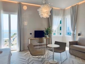 a living room with a couch and a table and chairs at Hotel Corallo in Imperia