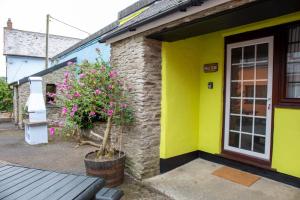a yellow house with a plant in front of it at Yetland Farm Holiday Cottages in Combe Martin