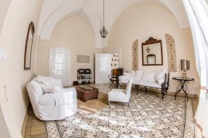 a living room with two white chairs and a table at Masseria Baroni Nuovi in Brindisi