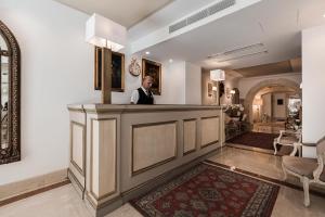 a man standing at a bar in a lobby at Osborne Hotel in Valletta