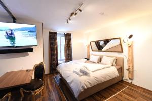 una camera da letto con un letto e una TV a schermo piatto di Hotel Krone Sihlbrugg a Sihlbrugg Dorf
