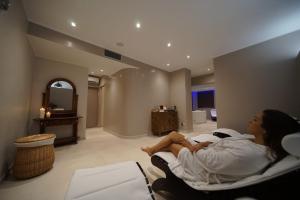 a woman laying on a bed in a hotel room at Hotel Galli - Wellness & Spa in Campo nell'Elba