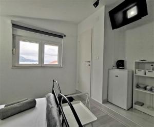 a white room with a refrigerator and a window at Accommodation Mala Plaža in Podaca