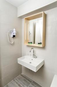 a white sink sitting under a mirror in a bathroom at Yadoya Hotel in Brussels