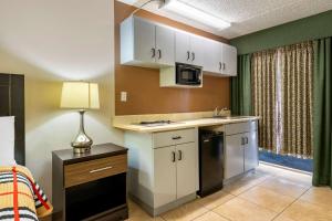 a kitchen with white cabinets and a sink and a lamp at Rodeway Inn Clearwater-Dunedin in Clearwater