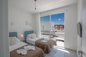 a room with two beds and a large window at Vie Bleu Villas in Protaras +209 photos