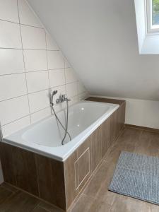 a bath tub with a shower in a bathroom at Ferienwohnung Horst in Nordenham +16 photos