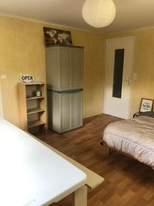 ein Schlafzimmer mit einem Bett und einem Tisch in einem Zimmer in der Unterkunft Appartement à deux pas du port de La Roche-Bernard in La Roche-Bernard