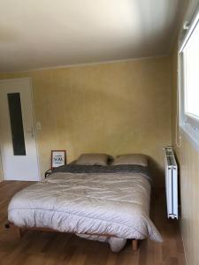 ein Schlafzimmer mit einem Bett in einem Zimmer in der Unterkunft Appartement à deux pas du port de La Roche-Bernard in La Roche-Bernard