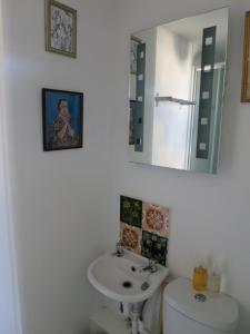 a bathroom with a sink, mirror, and toilet at Fitz House in Keswick