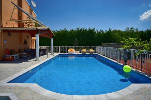 una piscina de agua azul frente a una casa en Villa Jolie Corfu Roda en Roda