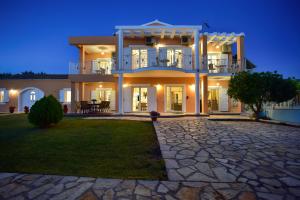 a large house with a stone driveway at Villa Jolie Corfu Roda in Roda