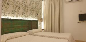 una camera con due letti e una finestra con tende di Hostal Macami a Pedro Abad