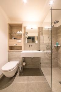 uma casa de banho com um lavatório, um WC e um chuveiro em Michels Inselhotel Vier Jahreszeiten em Norderney
