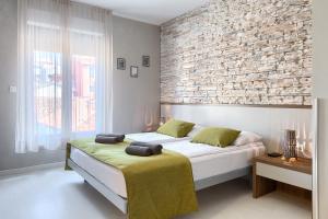 1 dormitorio con cama y pared de ladrillo en Pula City Center Accommodation en Pula