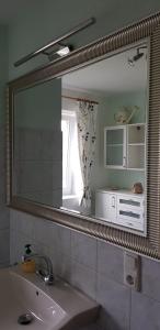 a bathroom mirror with a sink and a window at Villa-Musica in Fieberbrunn