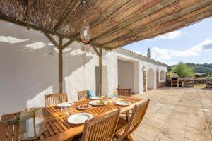 an outdoor patio with a wooden table and chairs at Finca Estancia de Son Gras in Ferreries