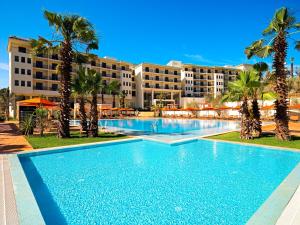 einen Pool mit Palmen vor einem Hotel in der Unterkunft Palais Médina Riad Resort in Fès