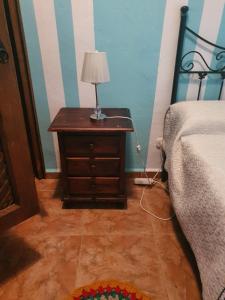 a bedroom with a bed and a table with a lamp at Casa mari carmen in Almuñécar