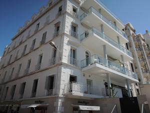 un edificio blanco con balcones en una calle en ACCI Cannes Croisette, en Cannes