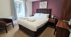 a bedroom with a large bed and a chair at The Lemon Tree in Wrexham