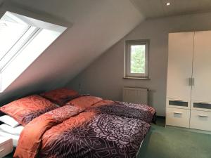 um quarto no sótão com uma cama e uma janela em Ferienwohnung Regine Settelmeier em Röttingen