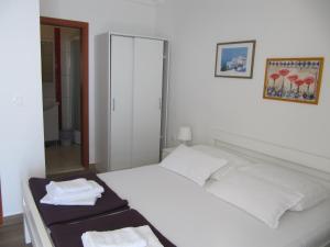 ein Schlafzimmer mit einem weißen Bett und Handtüchern darauf in der Unterkunft Villa Falcon in Podaca