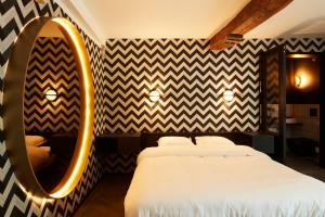 een slaapkamer met een groot bed en een spiegel bij Nonam Boutique Hotel Gent in Gent