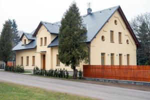 una grande casa bianca con una recinzione rossa di Penzion Červená voda -penzion s dotekem dálek a Červená Voda