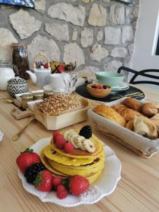 uma mesa com um monte de bolos e frutas e pão em Villa Moya, dependance privée Piscine & Spa em Châteauneuf-sur-Loire