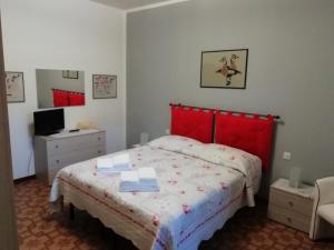 una camera con letto con testiera rossa e scrivania di Casa Pacini a Santa Fiora