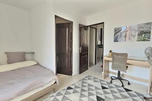 um quarto com uma cama, uma secretária e uma cadeira em Des appartements au calme dans un immeuble historique em Béziers
