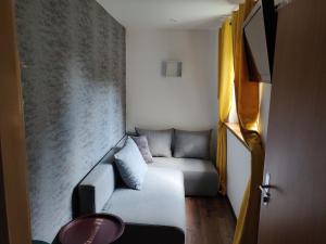 mały salon z kanapą i ścianą w obiekcie Apartament Studio 11 Starówka Konin w Koninie