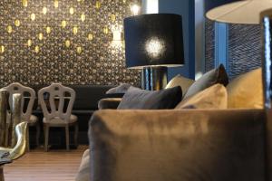 a living room with a couch and chairs and a lamp at 34 GuestHouse in Setúbal