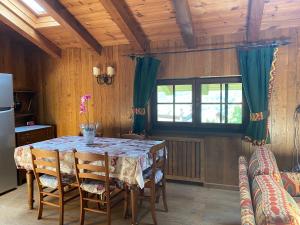 a kitchen with a table with chairs and a refrigerator at Appartamenti Espoire in La Salle