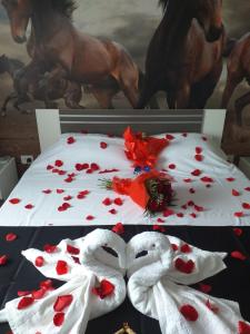 a table topped with two white swans covered in roses at Hotel Hobby in Hunedoara