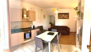 Una cocina y una sala de estar con mesa y sillas. en Apt 23 Residence delle Rose, en Peschiera del Garda